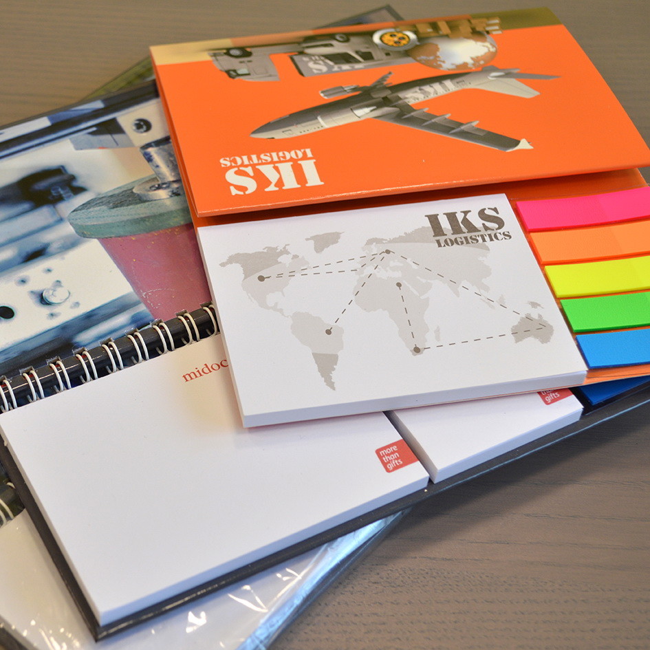 Tre calendari da scrivania con logo IKS e blocchetti sopra un tavolo