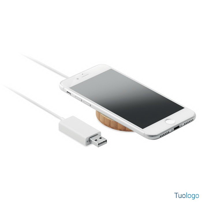 Telefono sopra caricatore tondo in bamboo con presa usb, su sfondo bianco