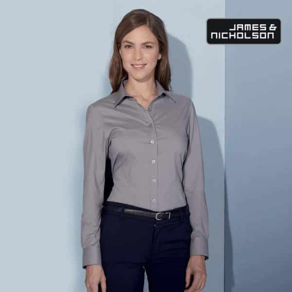 Ragazza con lunghi capelli castani camicia manica lunga acciaio pantaloni blu con cintura