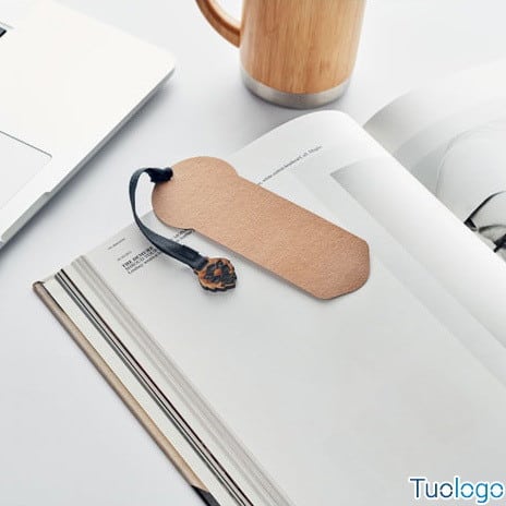 Segnalibro in carta con cordino in cotone e semi di pino su un libro