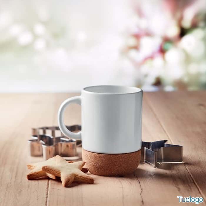 Tazza bianca con base in sughero su tavolo di legno