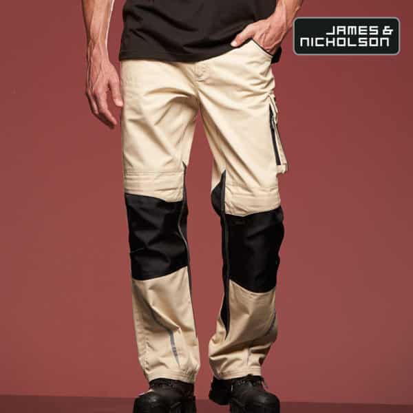 Dettaglio gambe uomo con pantaloni da lavoro beige multitasche e scarponcini su sfondo bordeaux
