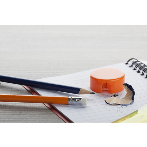 Temperino in plastica arancione sopra un tavolo