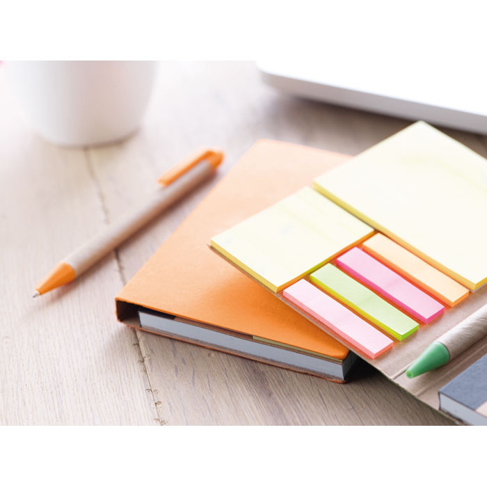 Bloc notes grigio scuro in carta riciclata con settanta fogli a righe e penna su un tavolo