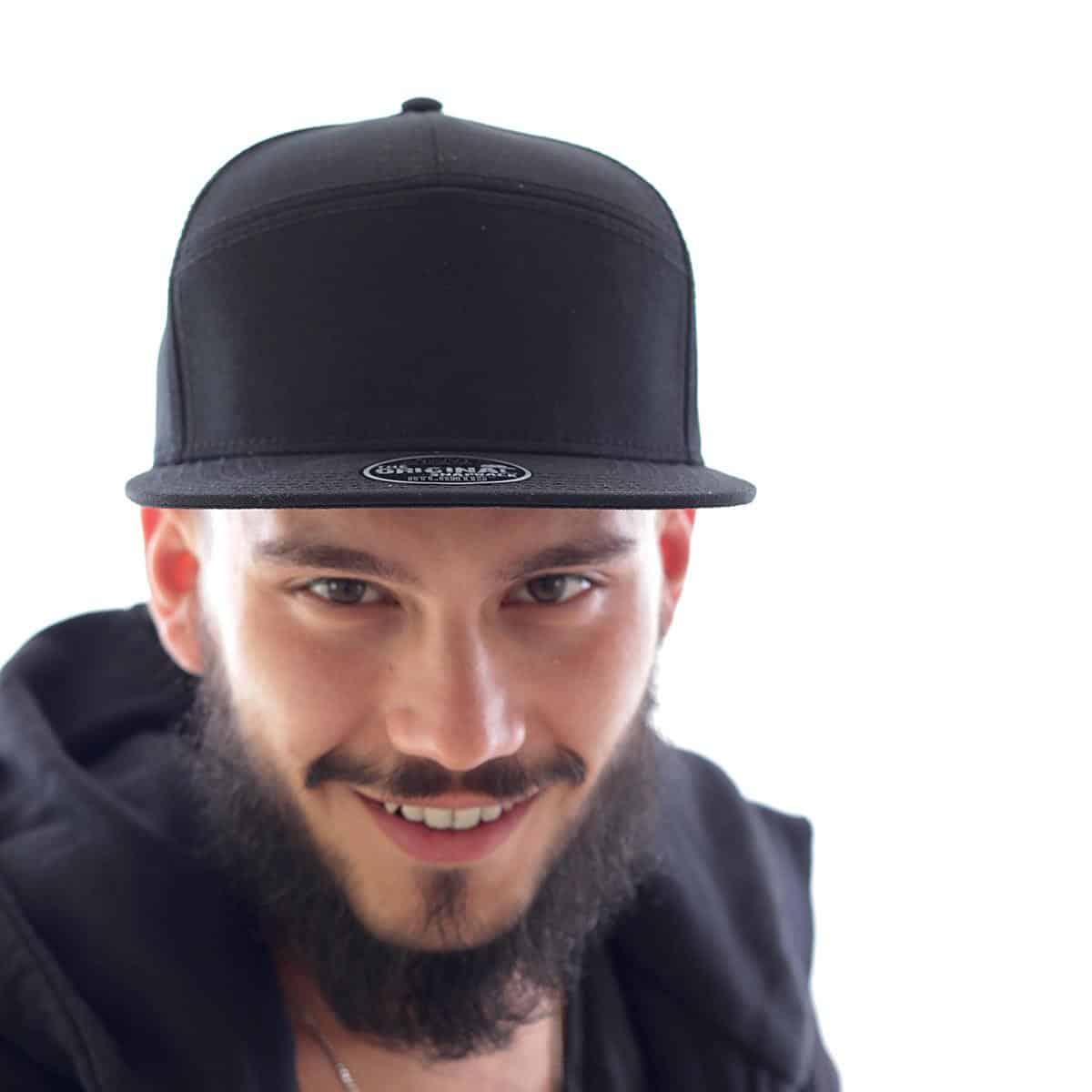 Primo piano di ragazzo sorridente con barba e cappellino baseball nero