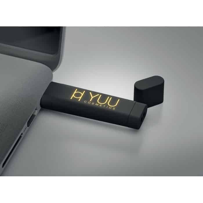 Chiavetta usb nera con logo illuminato con logo attacata al computer