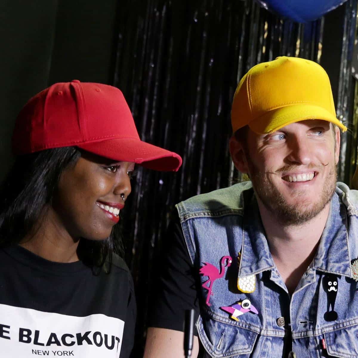 Primo piano di ragazza con cappellino baseball rosso e ragazzo con cappellino giallo