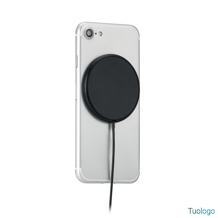 Telefono sopra caricatore tondo nero, su sfondo bianco