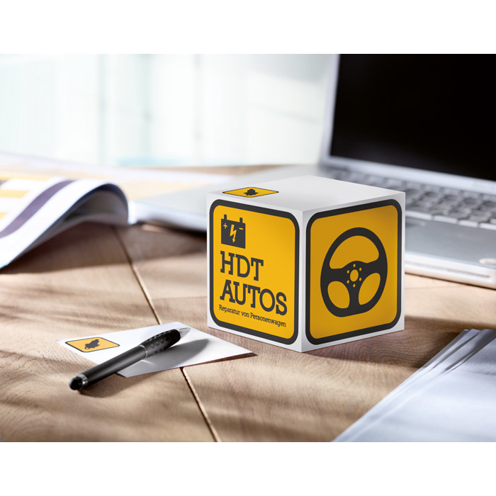 Blocco notes a forma di cubo con logo su un tavolo