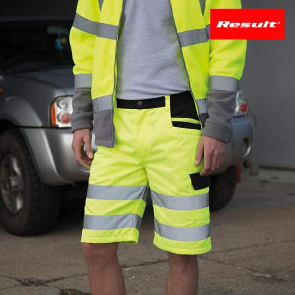 Dettaglio vita di un uomo con pantaloncini e gilet da lavoro giallo fluo con bande riflettenti
