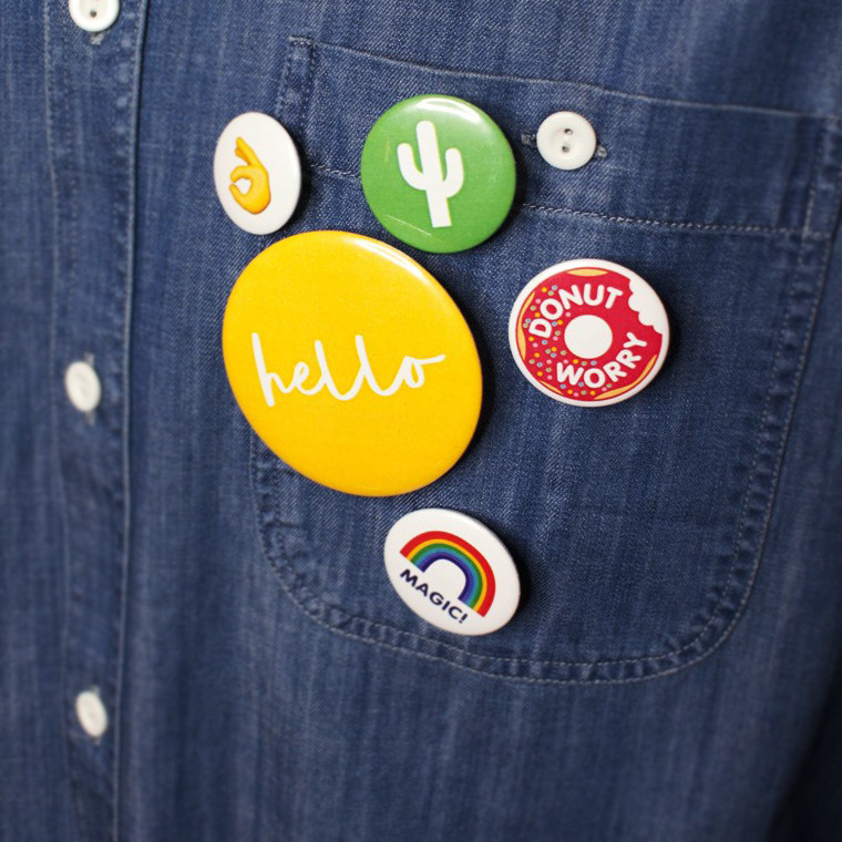 spille in latta rotonde di diversi diametri personalizzate a colori su camicia di jeans