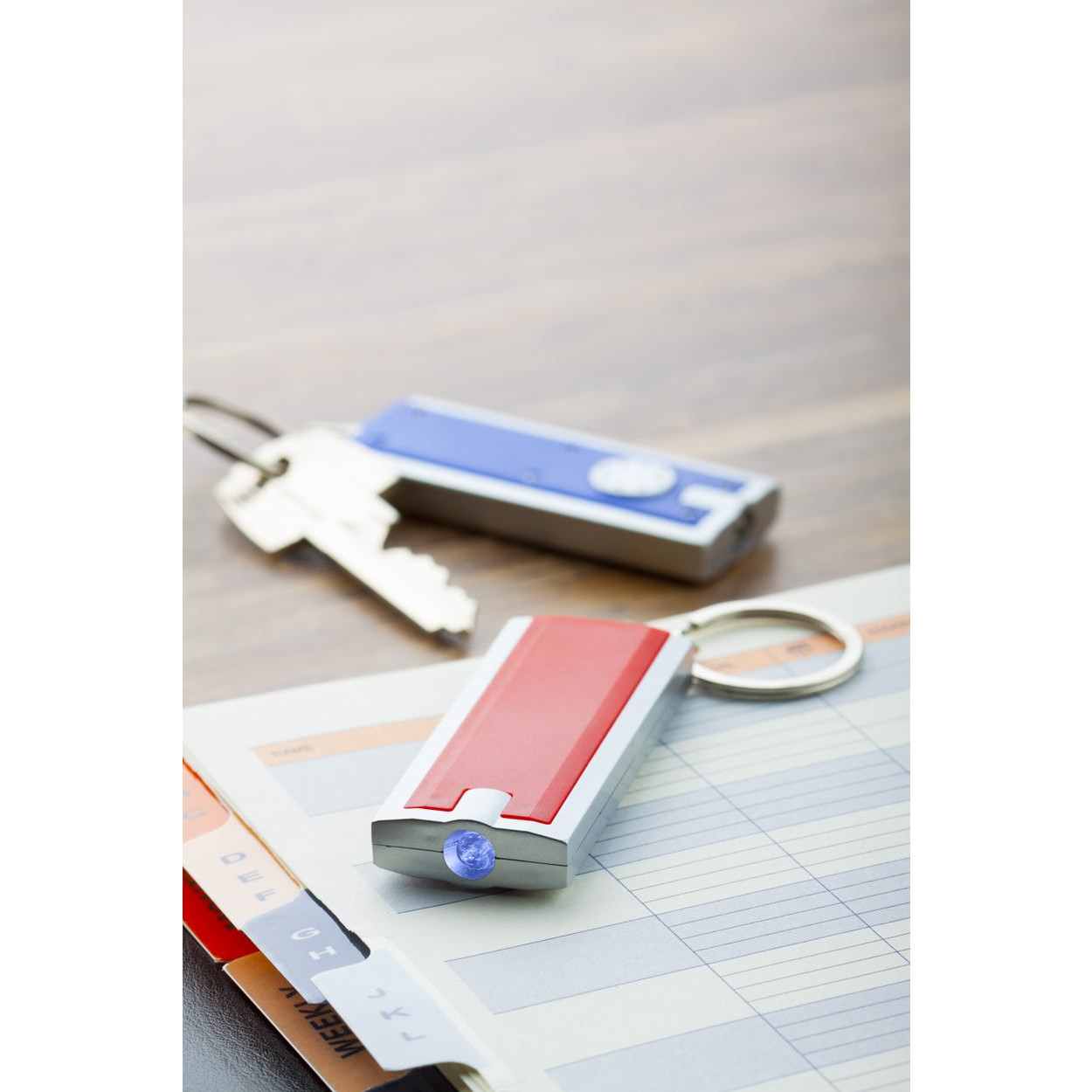 Torcia con portachiavi in plastica rossa e blu su un tavolo