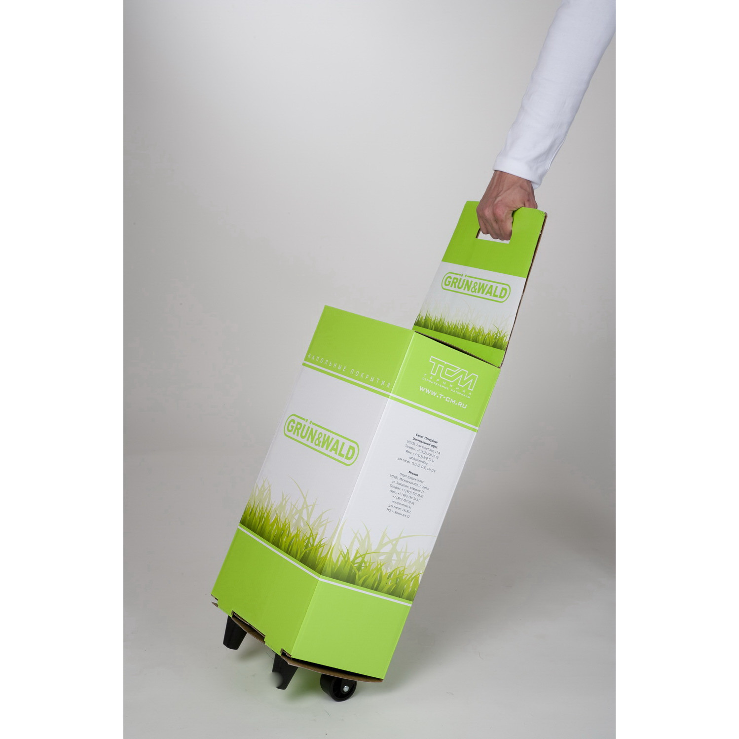 Mano che tira trolley bianco e verde in cartone con logo