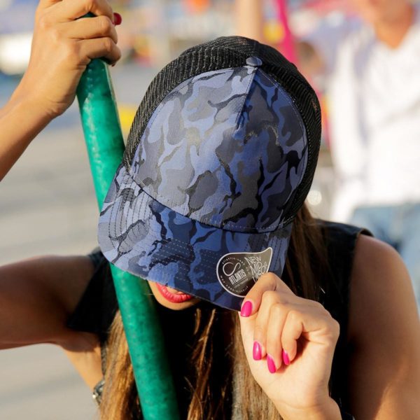 Ragazza con lunghi capelli neri e cappellino in rete nera con pannello fantasia blu