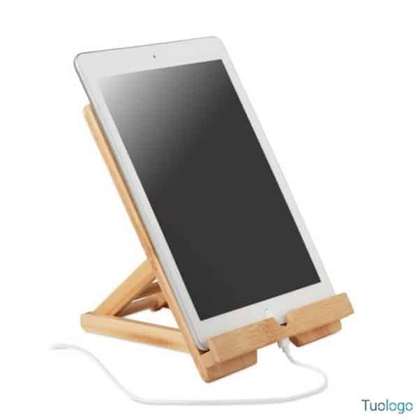 Tablet sopra sostegno in bamboo attaccato a caricatore, su sfondo bianco