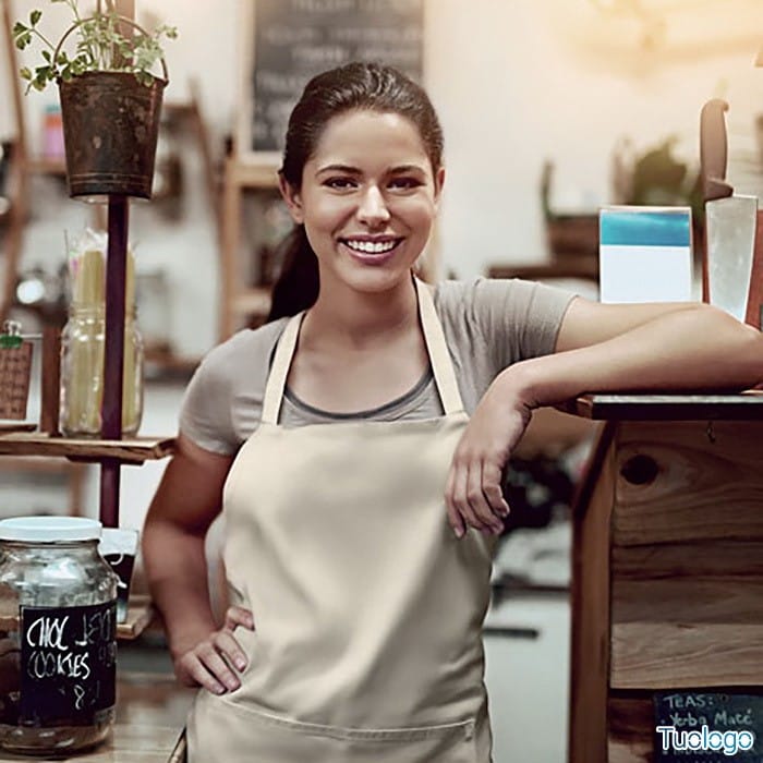 Donna in un negozio con grembiule beige con tasca frontale