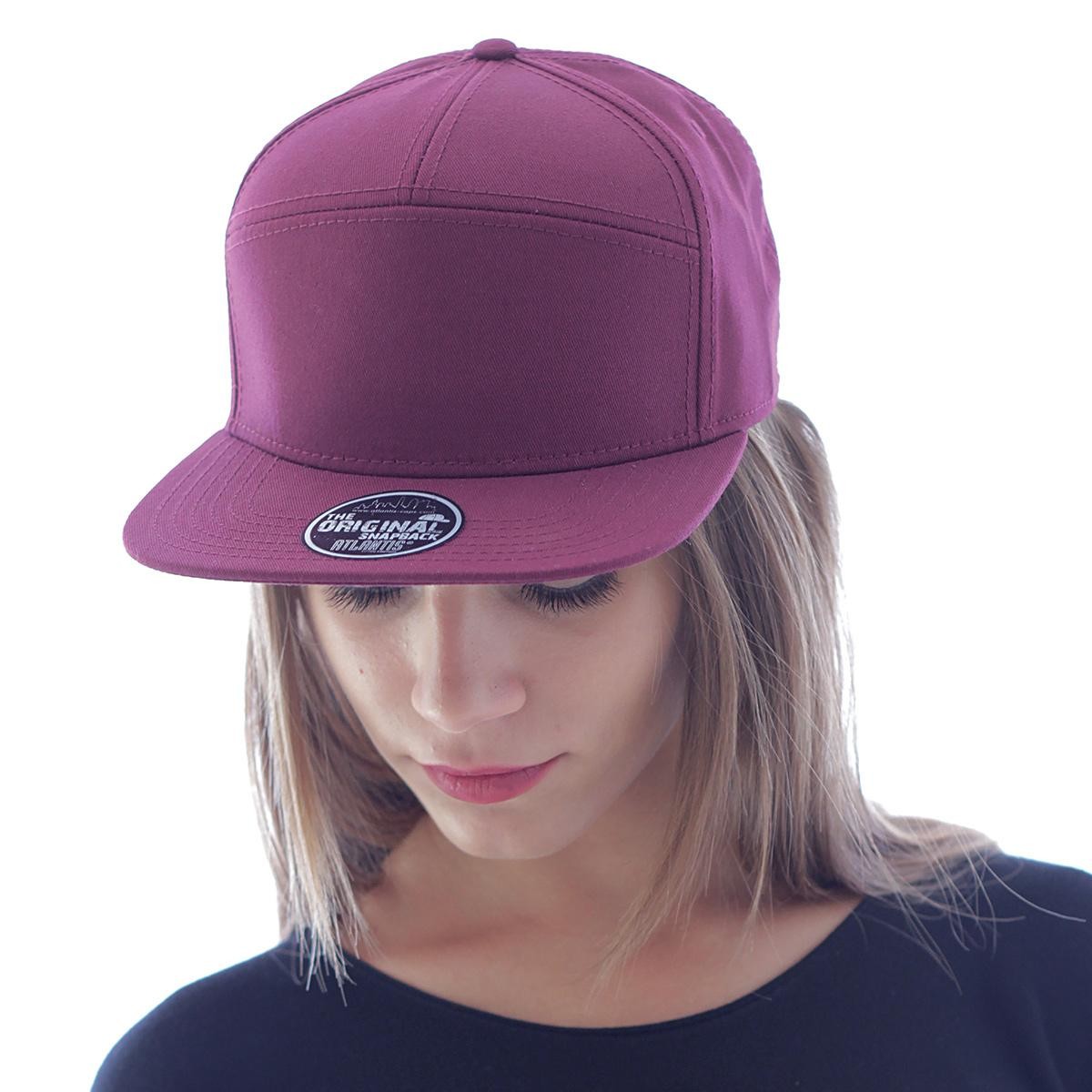 Ragazza con lunghi capelli biondi e cappellino con visiera piatta bordeaux