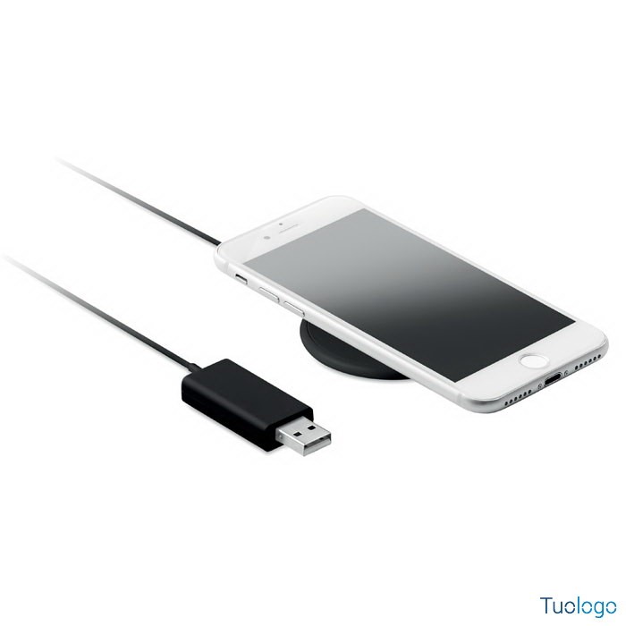 Telefono sopra caricatore tondo nero con presa usb nera, su sfondo bianco