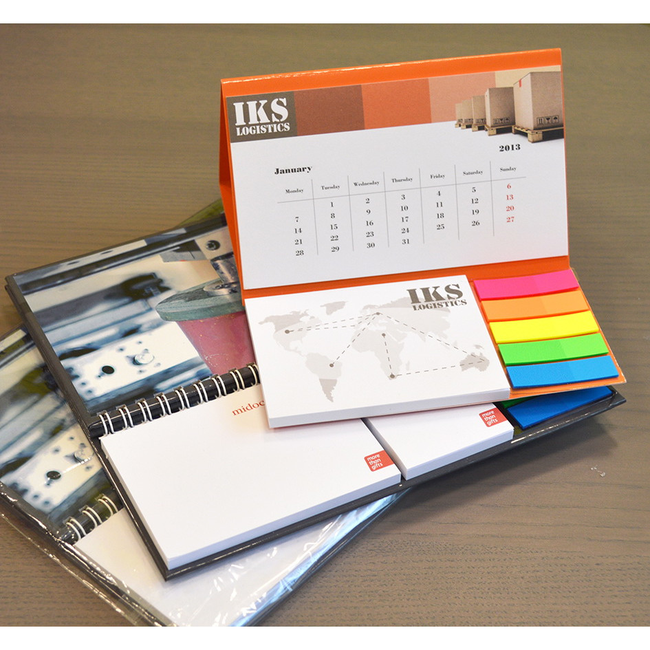 Tre calendario da scrivania personalizzati su tavolo, uno con logo IKS aperto