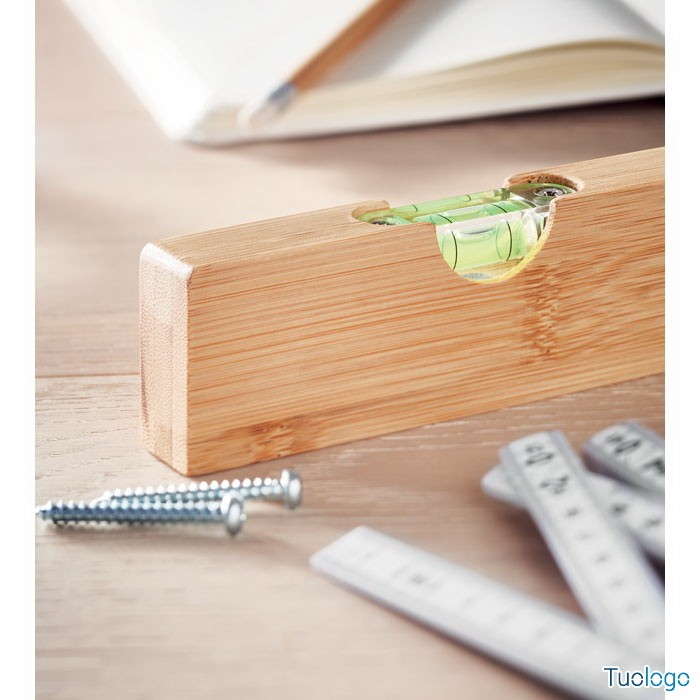 Apribottiglie in bamboo con livella, su tavolo di legno con viti e metro