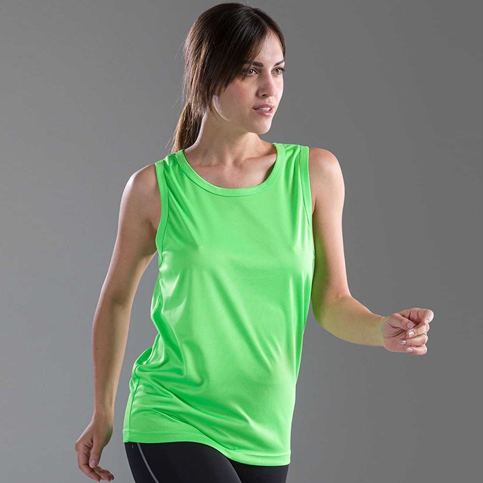 Donna in piedi con canotta verde, su sfondo grigio