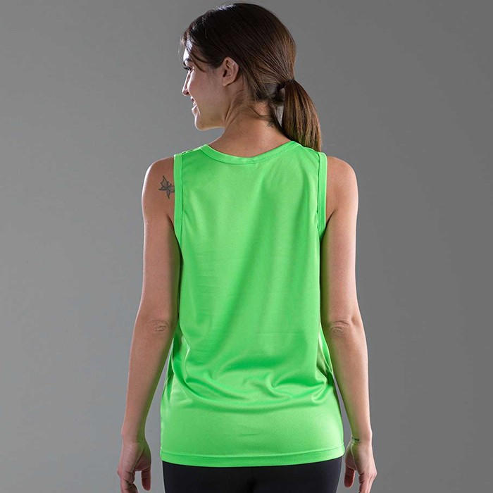 Donna in piedi, girata di schiena, con canotta verde, su sfondo grigio