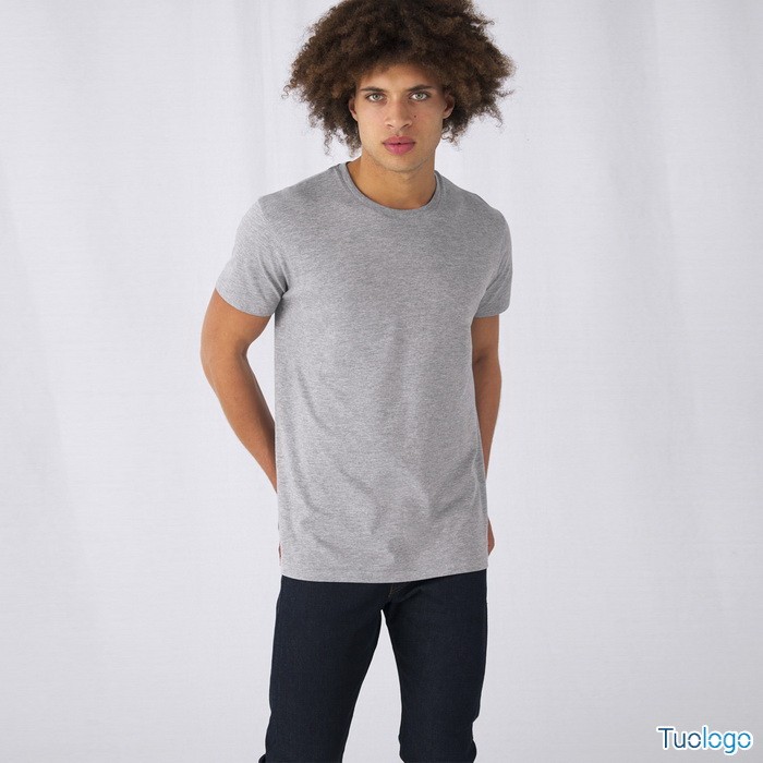 Uomo mulatto in piedi con tshirt maniche corte grigia su sfondo bianco