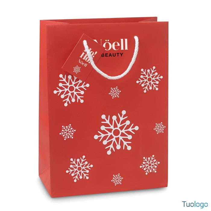 Shopper rossa con fiocchi di neve bianchi stampati sopra e cartellino rosso con logo