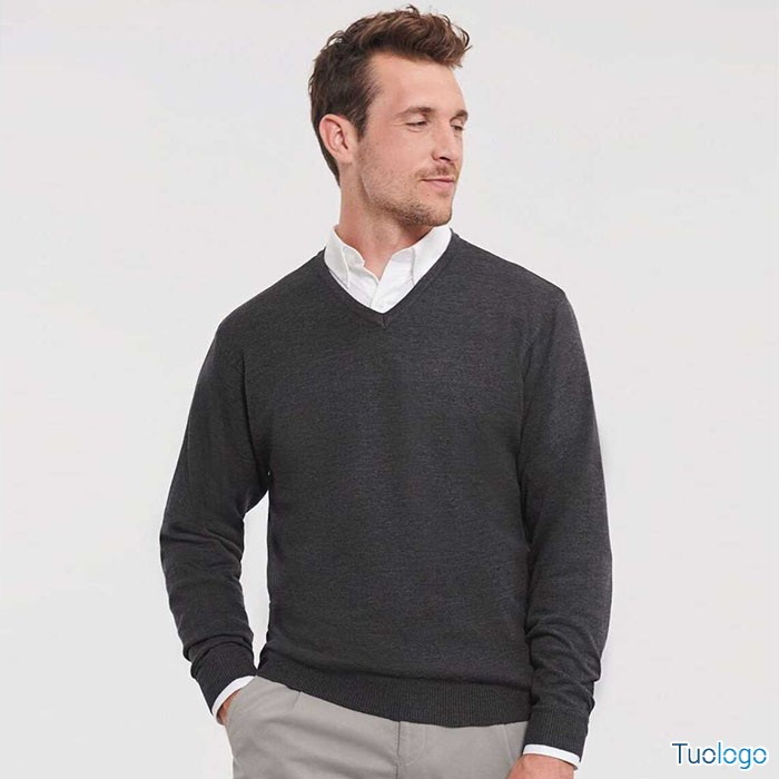 Uomo in piedi con maglioncino grigio scuro, su sfondo bianco