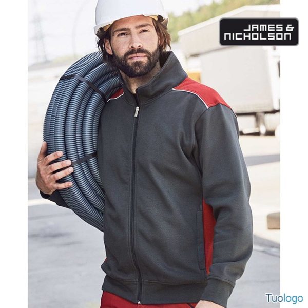Uomo in piedi con tubi in mano con felpa grigia con inserti rossi sulle spalle e zip lunga